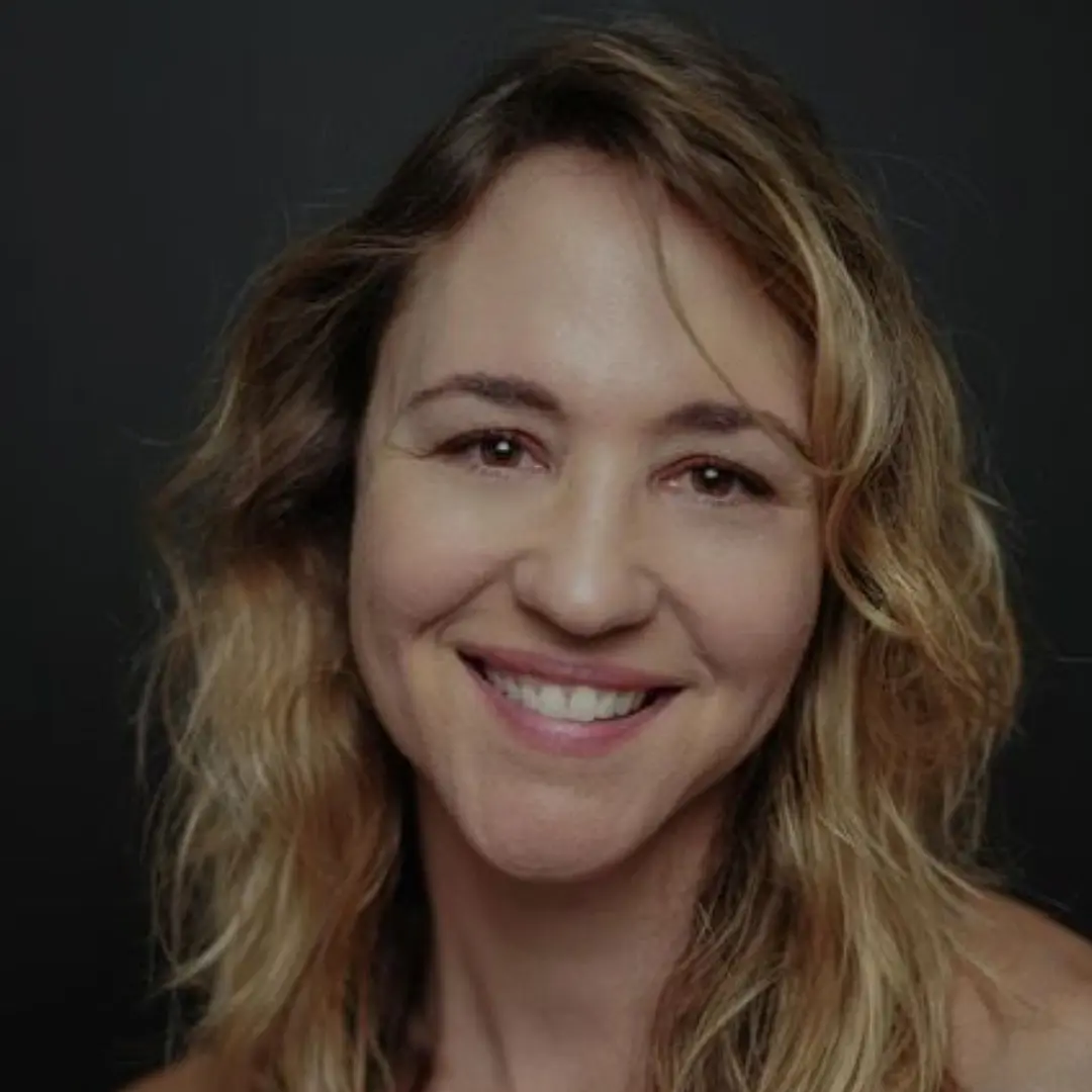 A woman with long hair smiles for the camera.